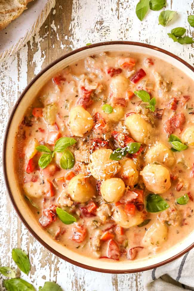 top view of gnocchi soup recipe in a bowl garnished with Parmesan and basil