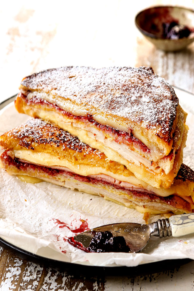 Monte Cristo recipe sliced in half on a plate dusted with powdered sugar