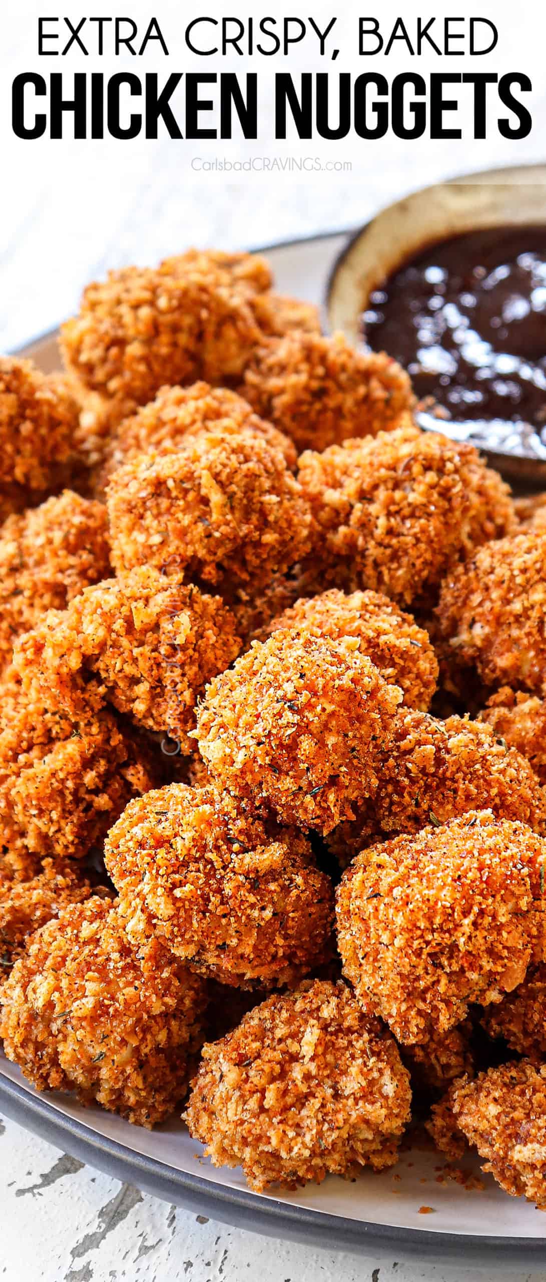 up close view of baked chicken nuggets stacked on a plate showing how crispy they are