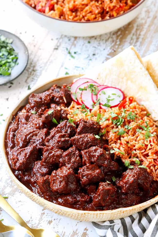 showing how to serve Chile Colorado by serving Mexican rice and tortillas with the stew