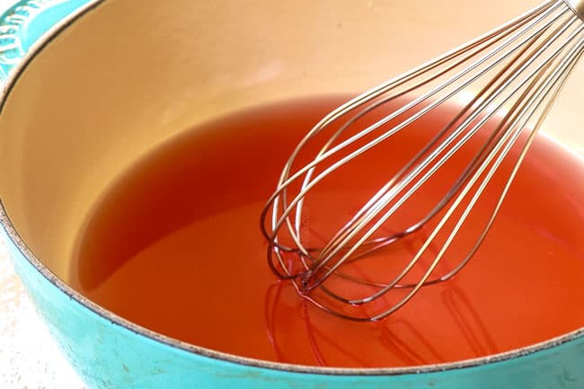 showing how to pickle red onions by simmering vinegar, sugar, salt and water in a saucepan