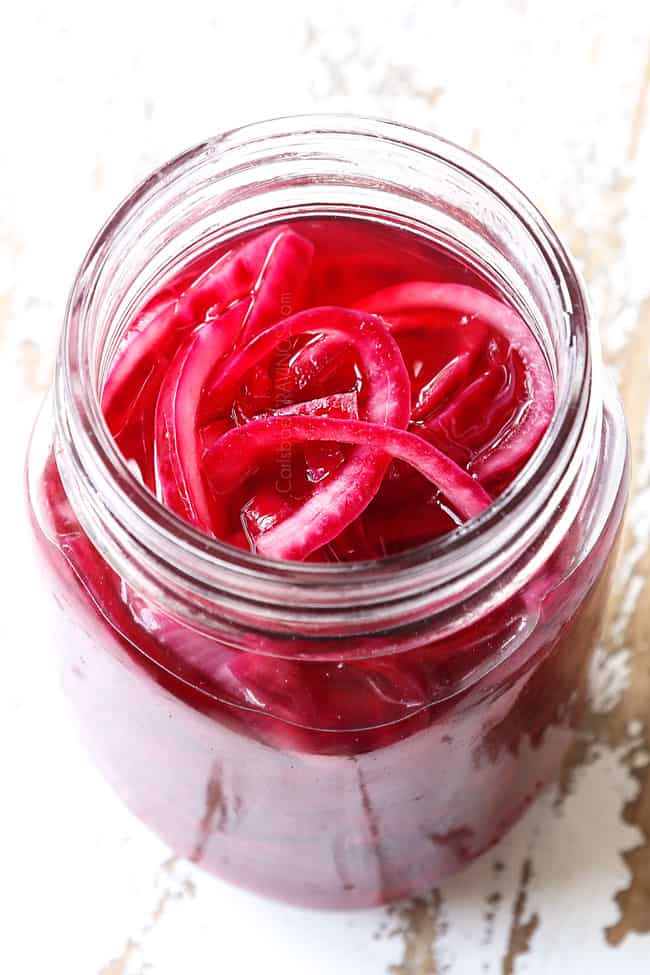 showing how to pickle red onions by letting onions rest in glass jar to pickle
