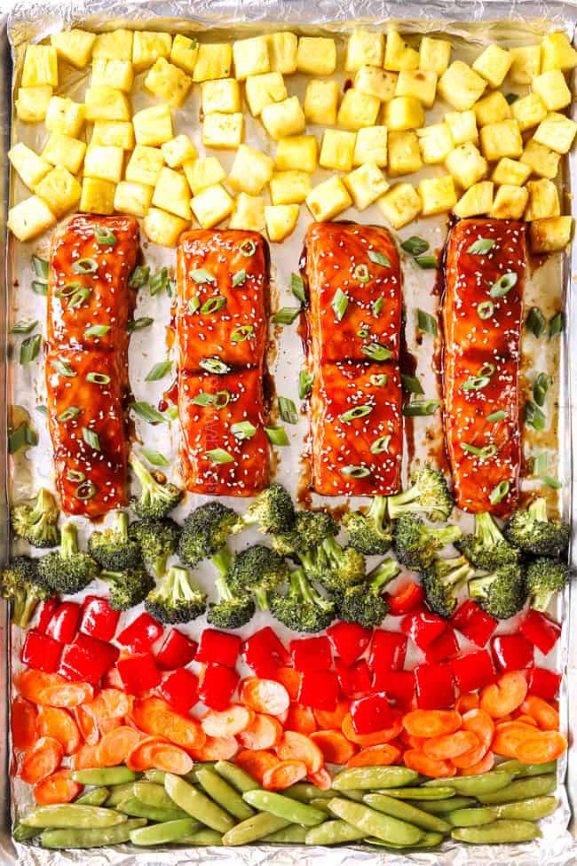 showing how to bake teriyaki salmon by lining it on a baking pan with pineapple and vegetables