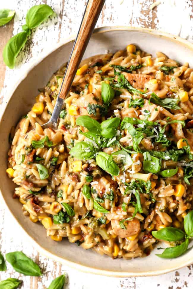 top view of basil chicken recipe in a bowl garnished with fresh basil and Parmesan