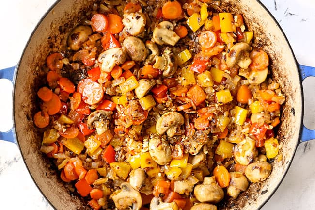 showing how to make chicken cacciatore recipe by sauteing carrots, onions, bell peppers in a pot