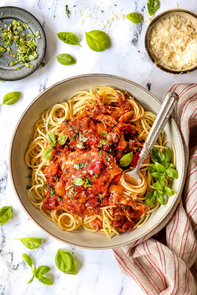 top view of chicken cacciatore served over spaghetti in a bowl
