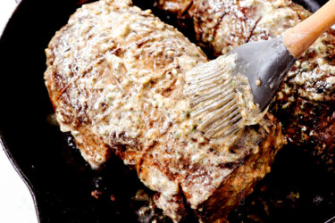 showing how to cook beef tenderloin by slathering with herb butter before the beef goes in the oven