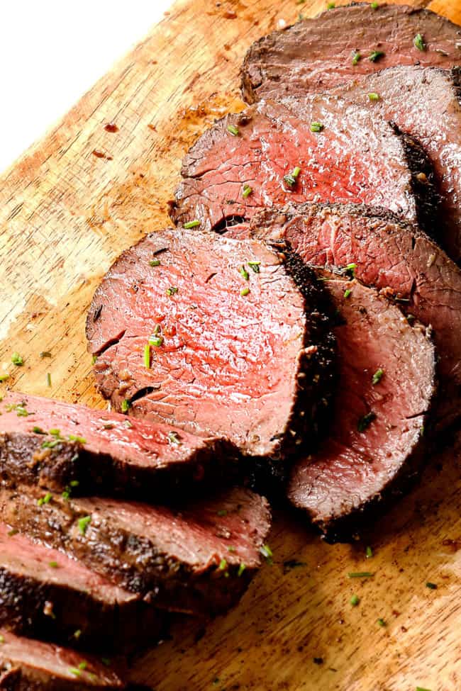 beef tenderloin recipe on a wood cutting board showing how juicy it is