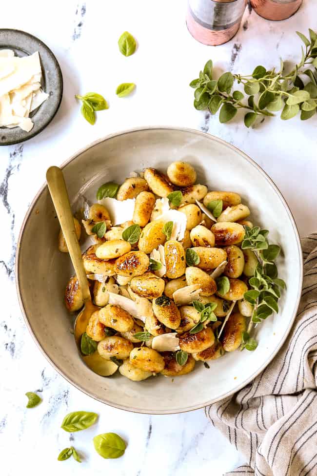top view of gnocchi recipe with sauce in a bowl with a gold spoon