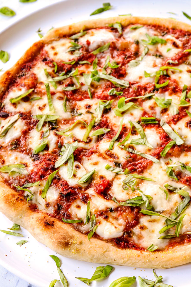 side view of homemade margherita pizza recipe with fresh basil and a thin, crispy crust