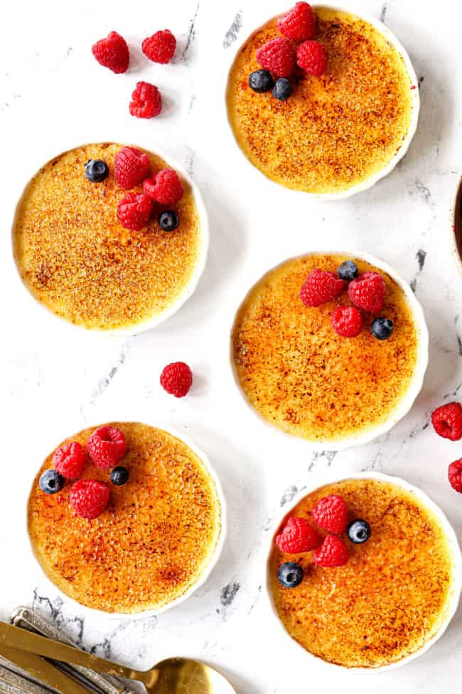 showing how to garnish creme brûlée recipe with top view of creme brulee with raspberries and blueberries