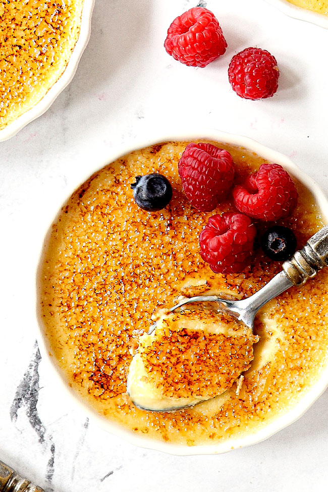 top view of best crème brûlée recipe with a spoon in the custard