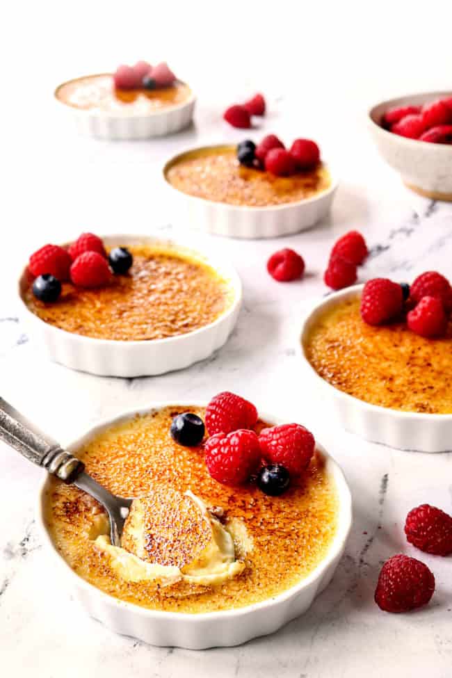 crème brûlée in white ramekins on a marble counter top
