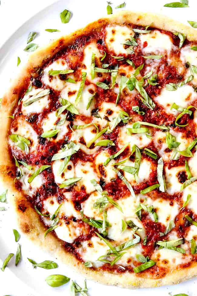 showing how to use pizza sauce recipe by adding mozzarella and basil to pizza sauce