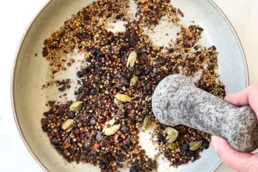 showing how to make corned beef by crushing corned beef spices with a mortar and pestle