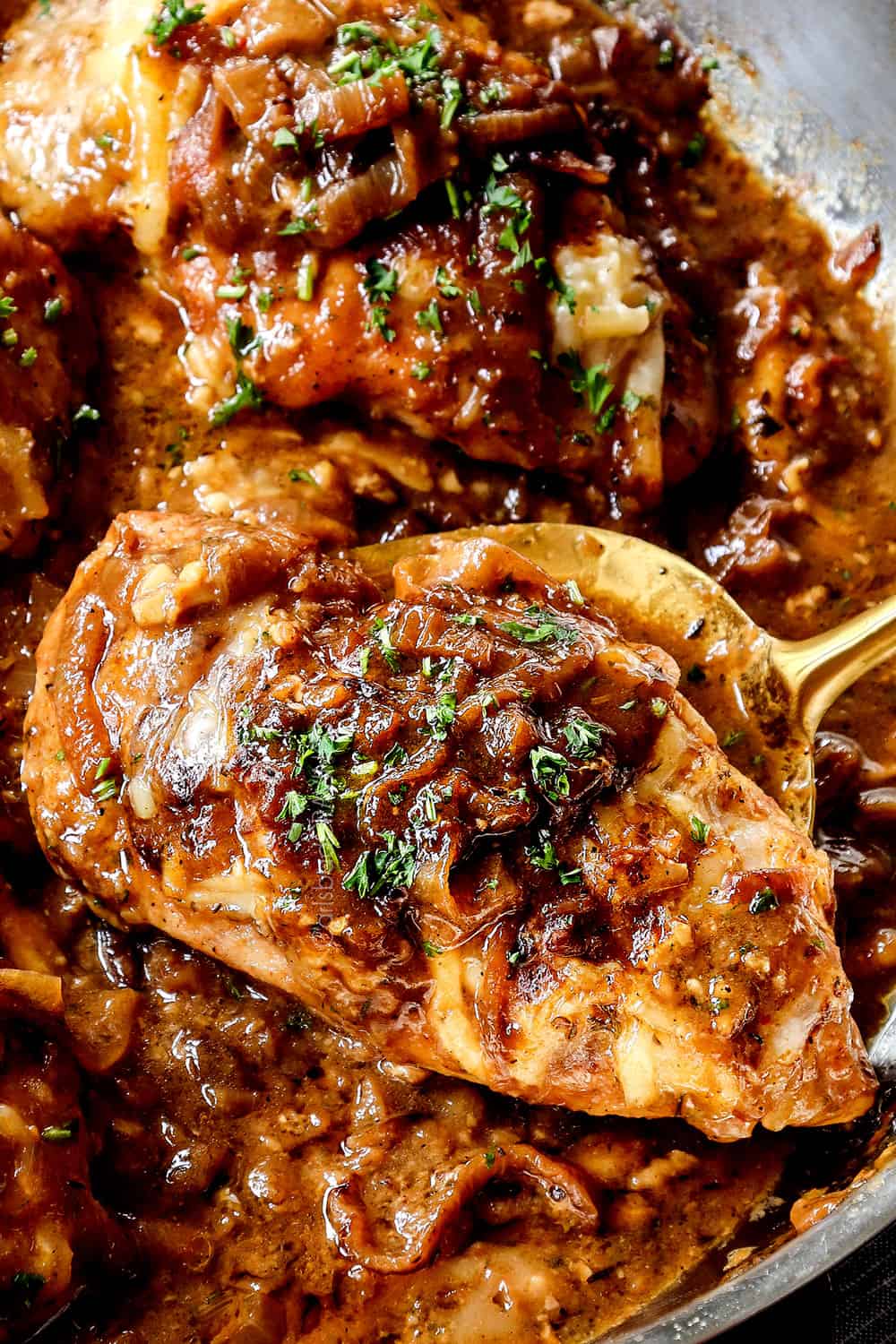 a ladle picking up a piece French onion chicken