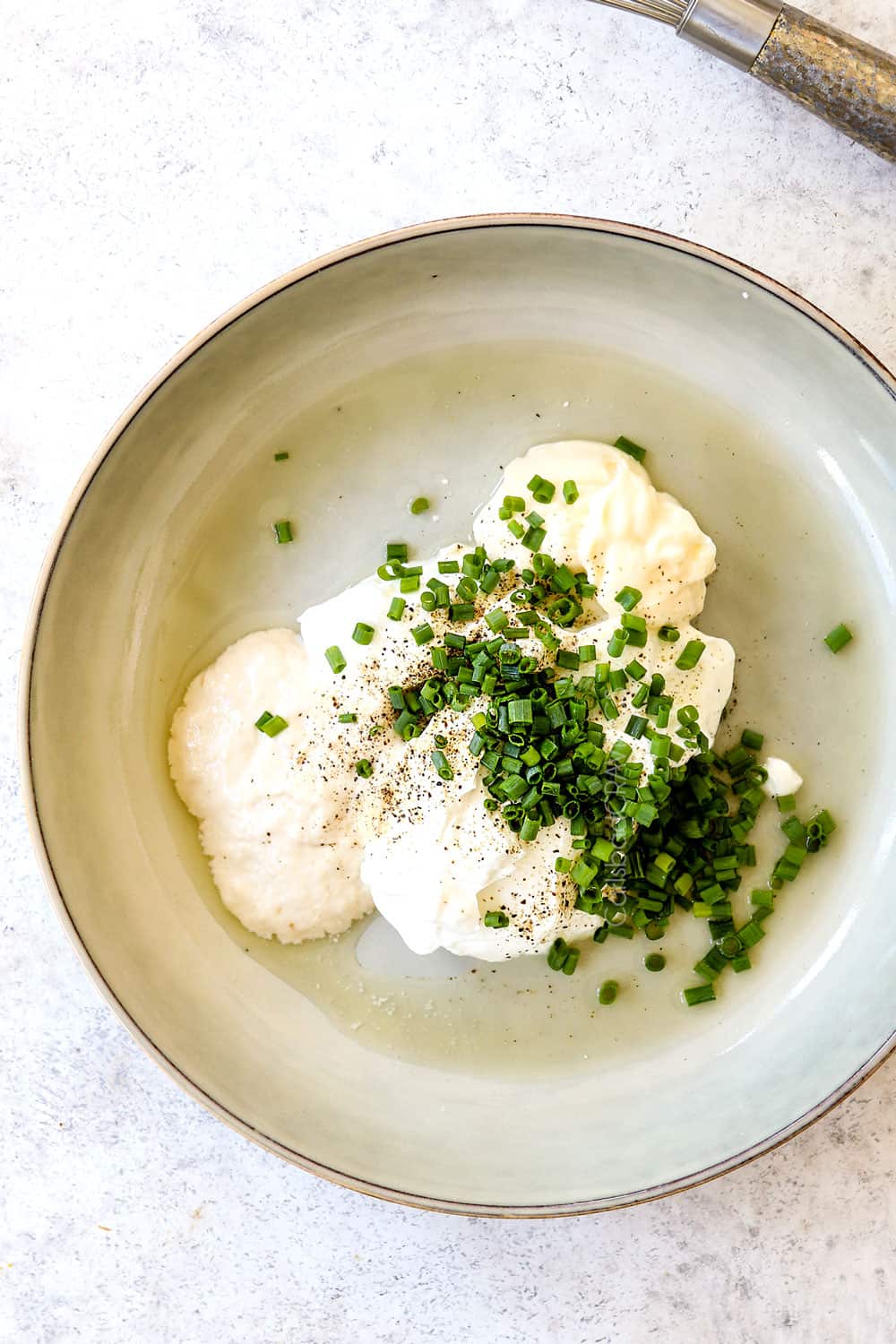 showing how to make horseradish sauce recipe by adding sour cream, mayonnaise, chives lemon juice, salt and pepper to a bowl