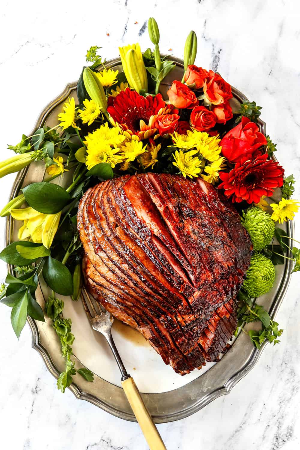 Ham glaze recipe with brown sugar and pineapple on a platter with leaves and flowers
