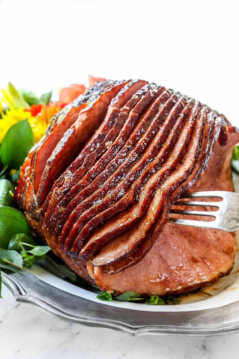 a fork taking a piece of spiral ham with brown sugar pineapple ham glaze