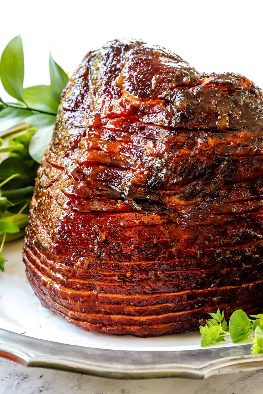 showing how to make spiral ham with brown sugar pineapple ham glaze by resting the ham on a white platter