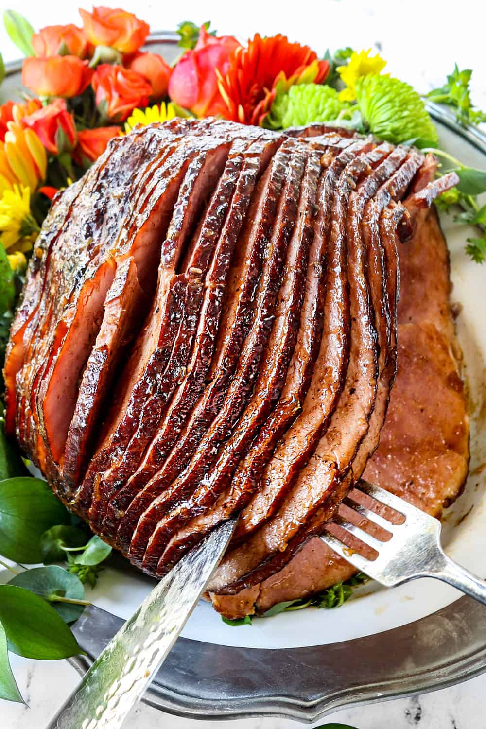 showing how to carve pineapple ham on a white platter
