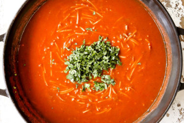 showing how to make fideo by adding cilantro and lime juice