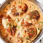 showing how to make Cajun chicken recipe by adding chicken to skillet with sauce