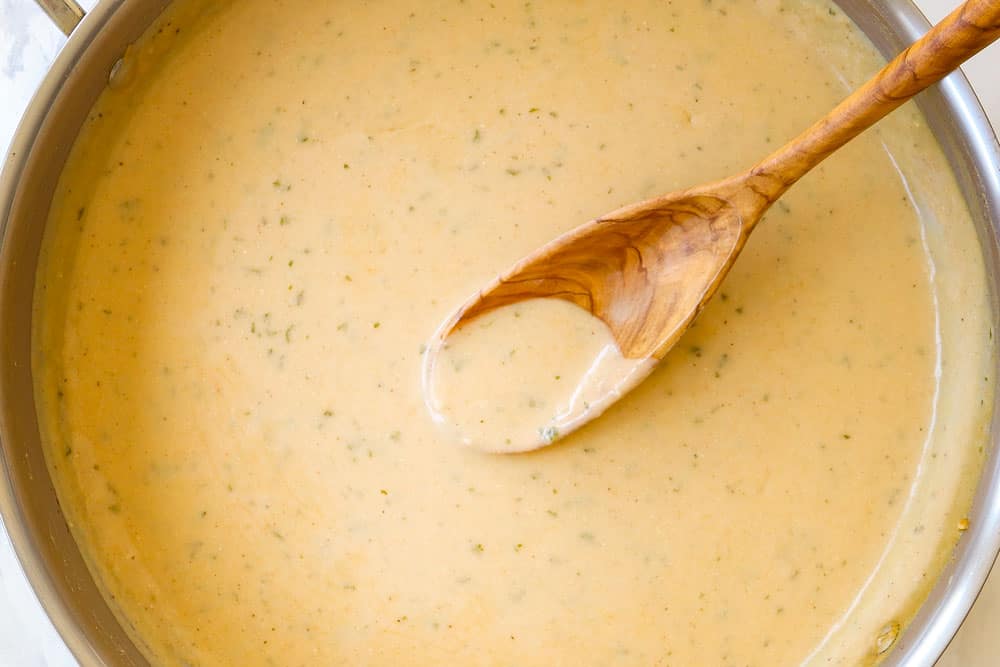 a collage showing how to make chicken cordon bleu casserole by simmering sauce until thickened