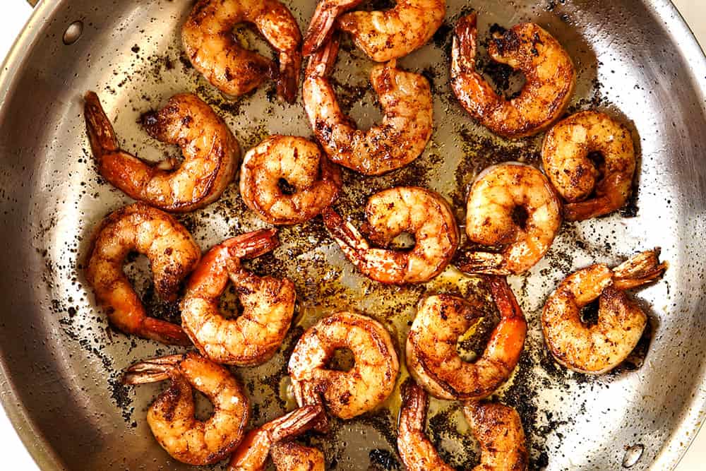 showing how to make easy cilantro lime shrimp recipe by cooking shrimp in a skillet in a single layer