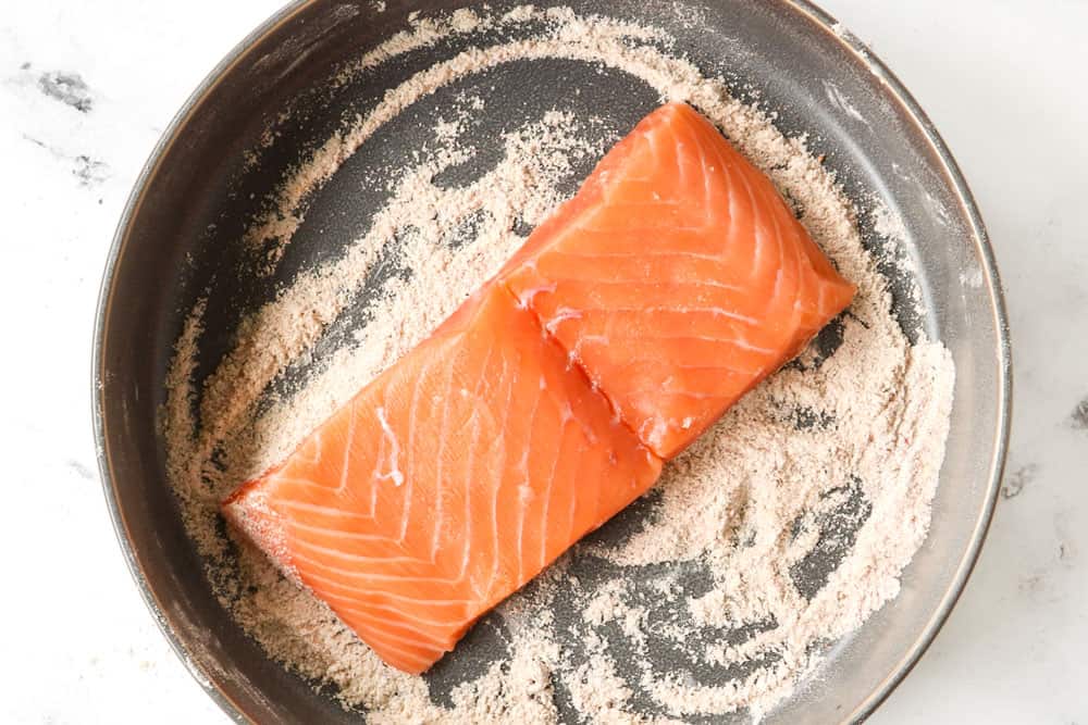 showing how to make honey glazed salmon recipe by dredging salmon fillet in flour and seasonings