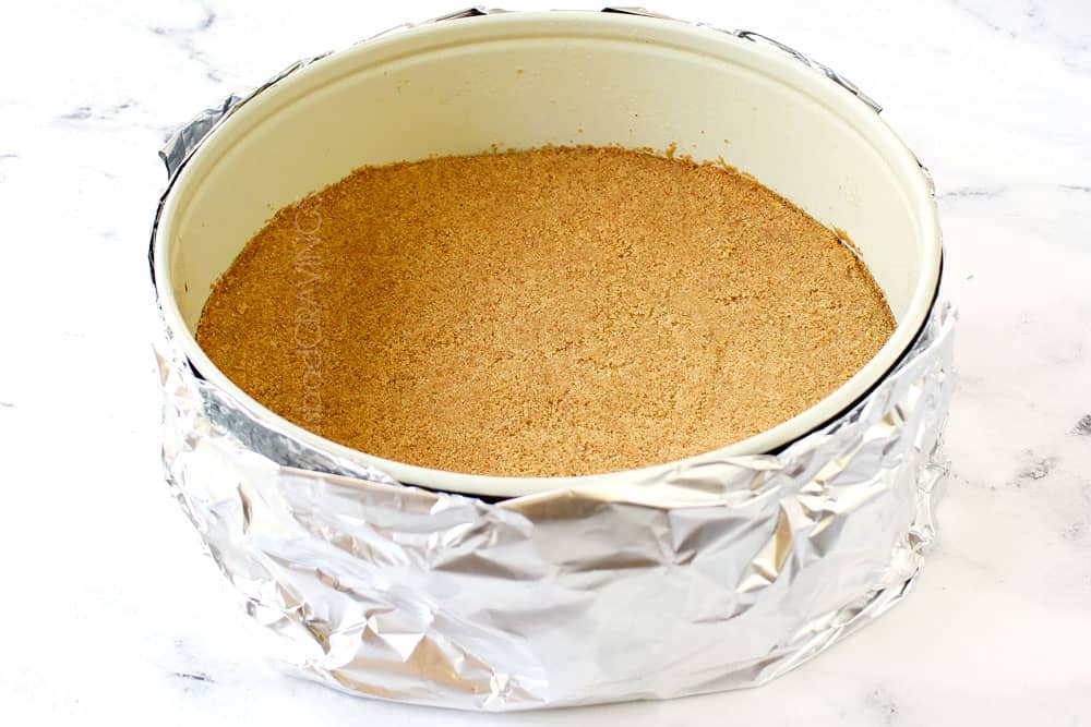 showing how to waterproof cheesecake by folding foil up around the springform pan