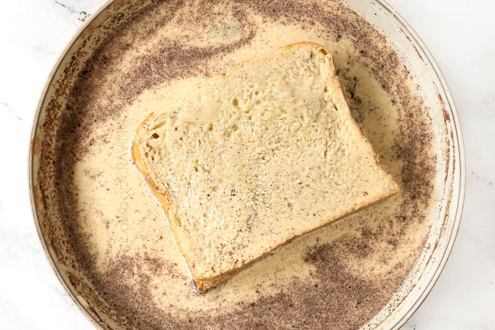 showing how to make stuffed French toast recipe by dunking French toast in egg milk mixture