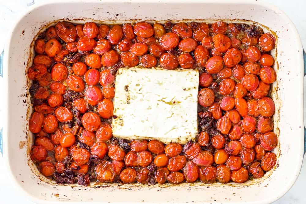 showing how to make tiktok feta pasta by baking feta pasta until the tomatoes are bursting and feta is soft