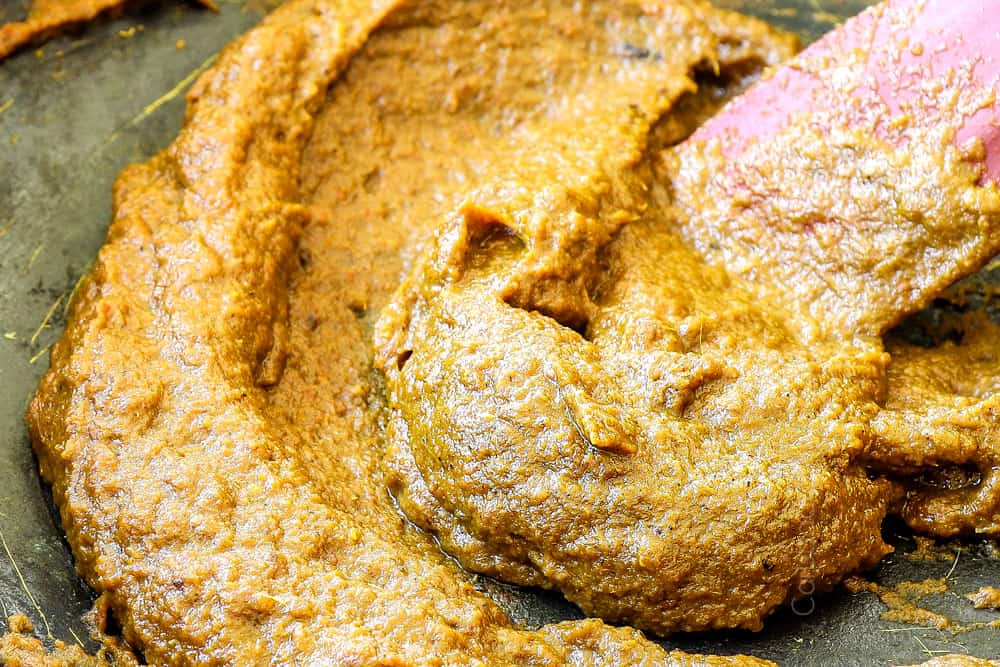 showing how to make beef rendang recipe by cooking curry paste in a pot until it reduces and caramelizes