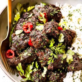 showing how to serve beef rendang by adding to a bowl with rice