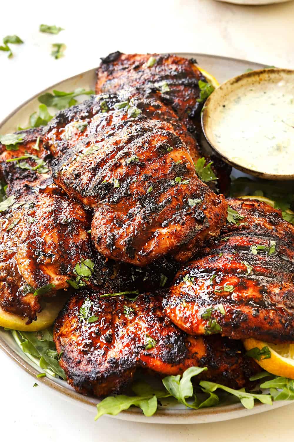 up close of harissa chicken thighs on a platter showing how juicy they are