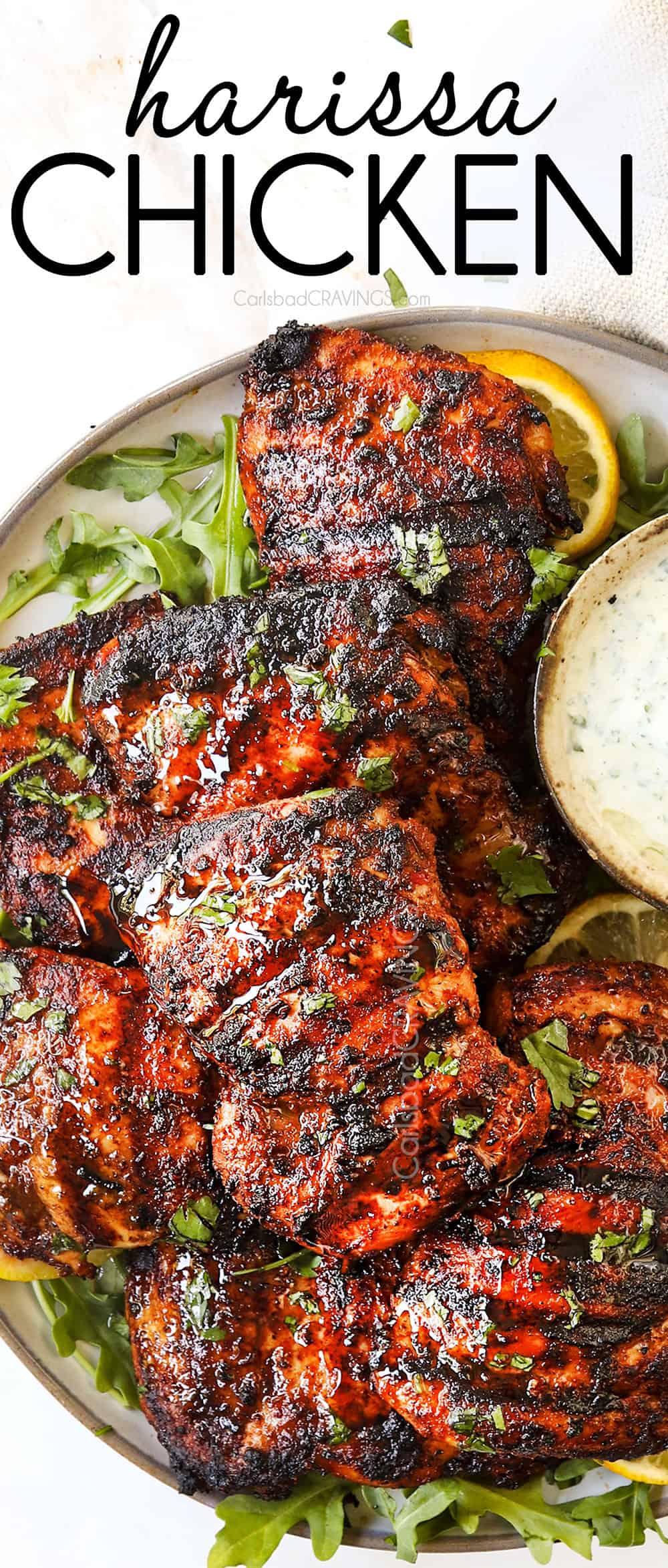 top view of harissa chicken recipe stacked on a white platter after grilling