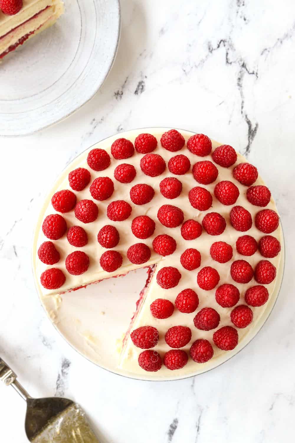 top view of white cake garnished with raspberries on top