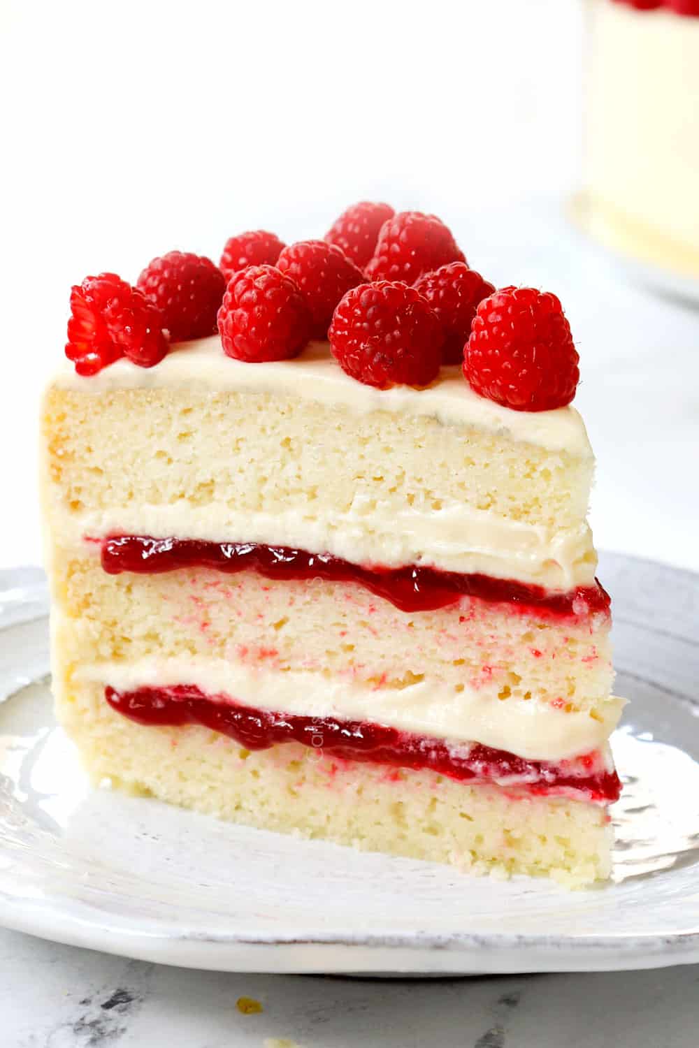 a slice of white chocolate raspberry cake on a plate