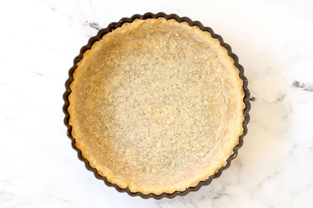 showing how to make Quiche Lorraine by blind baking dough before adding the filling