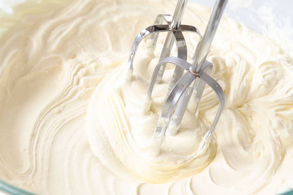 showing how to make cheesecake salad by whipping cheesecake pudding mix with heavy cream