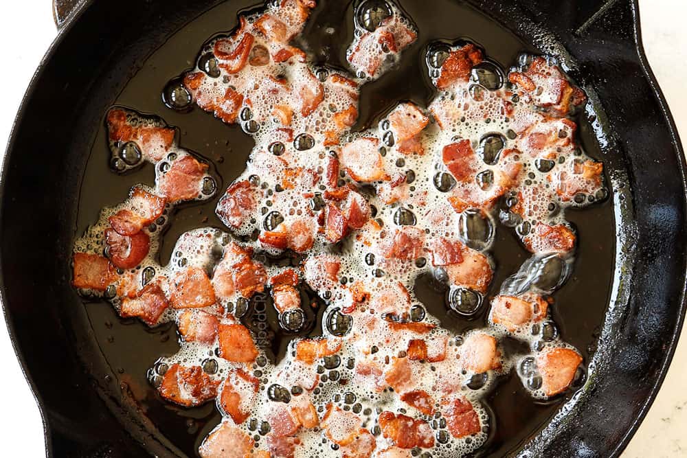 showing how to make hot German potato salad by cooking bacon pieces in a cast iron skillet until crispy
