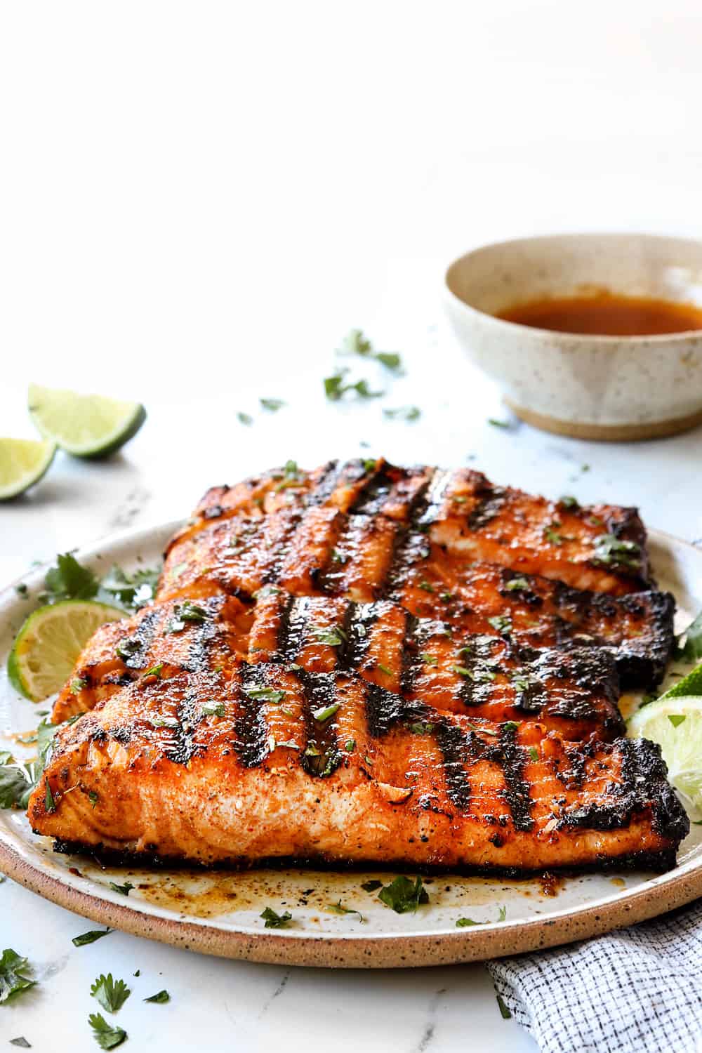 grilled salmon recipe on a plate garnished by cilantro