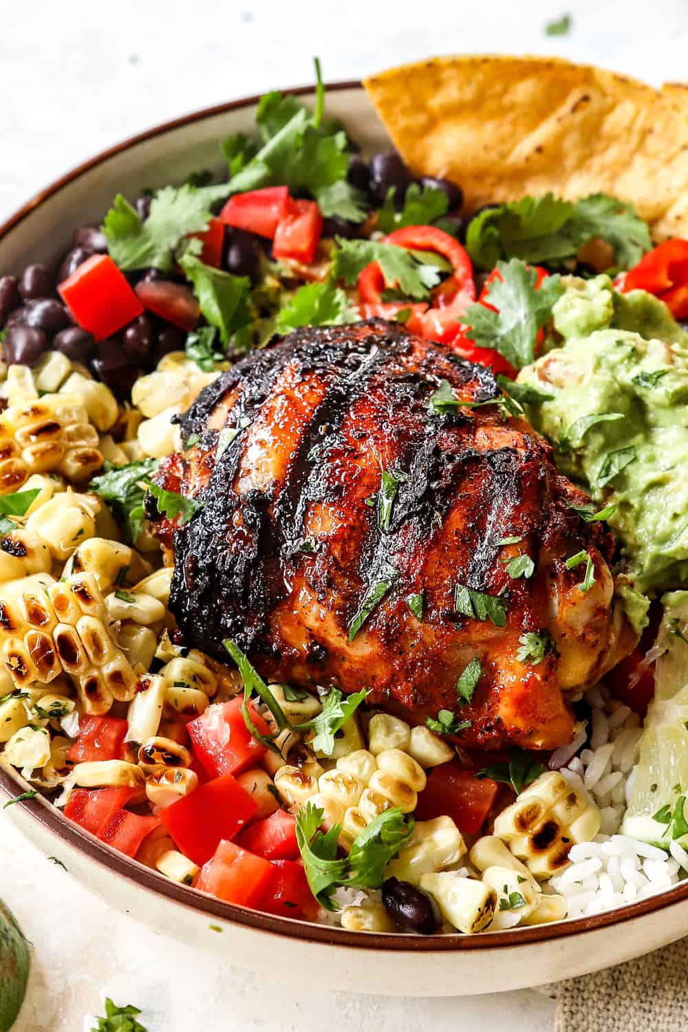 showing how to serve pollo asado with sides by adding to rice, corn, and salad