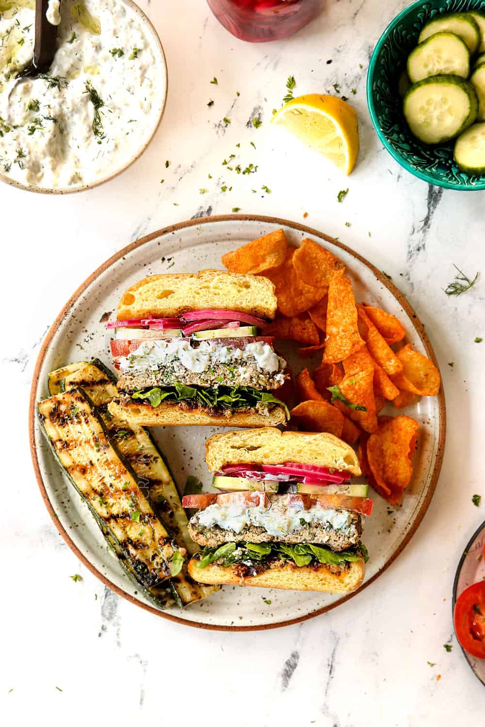 top view of sliced Greek lamb burger with grilled zucchini and chips