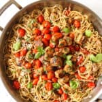 top view of bruschetta chicken pasta recipe with chicken, tomatoes and basil