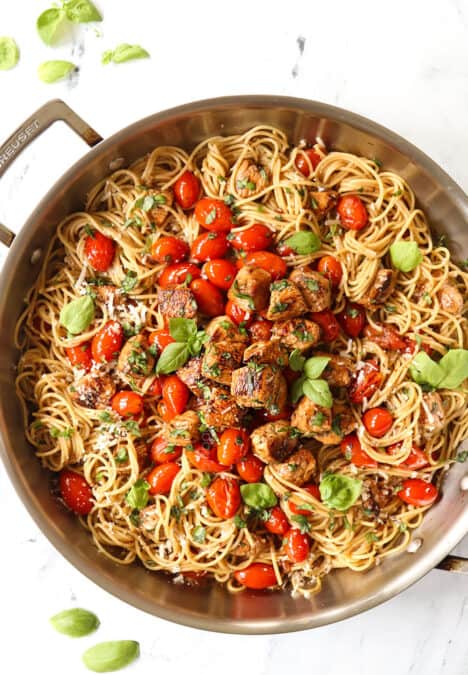 top view of bruschetta chicken pasta recipe with chicken, tomatoes and basil