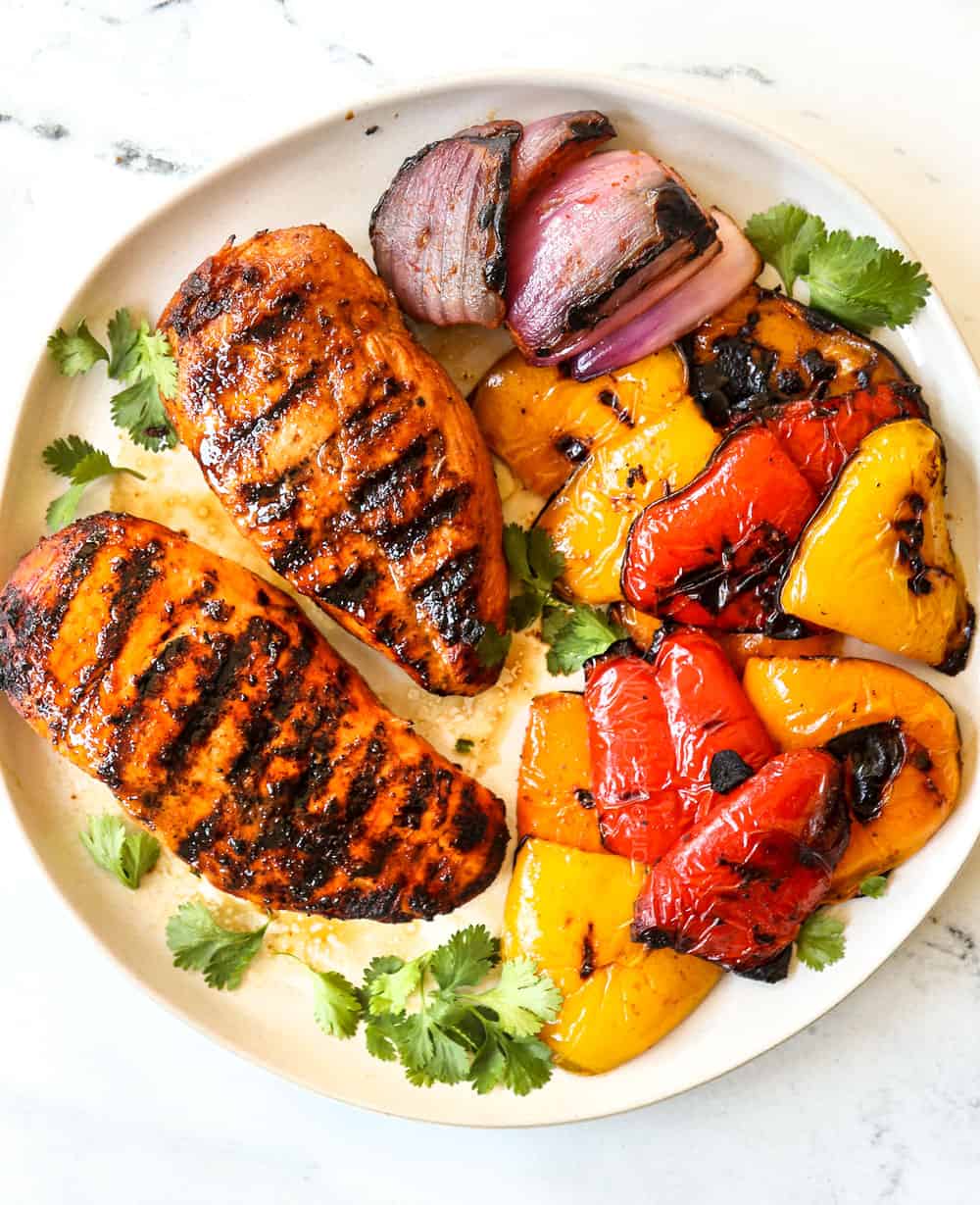 showing how to make chicken fajita salad by grilling chicken and bell peppers