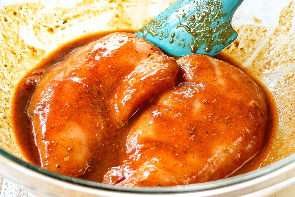 showing how to make chicken fajita salad by marinating chicken in a glass bowl