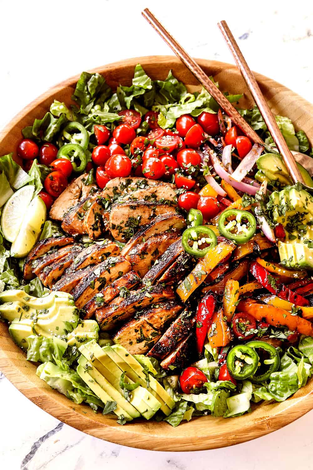 chicken fajita salad (chicken salad recipe) with chicken, bell peppers, red onions, tomatoes, avocados, cilantro in a wood bowl